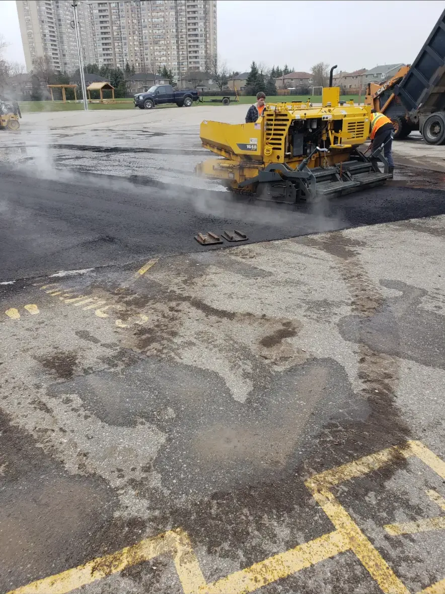 Asphalt paving crew repairing commercial pavement